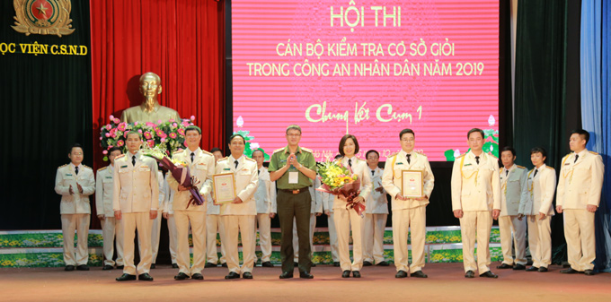 Thiếu tướng Đặng Văn Chấn, Phó Chủ nhiệm thường trực UBKT Đảng ủy Công an Trung ương  trao giải khuyến khích cho Đội thi Học viện Chính trị CAND và Bộ tư lệnh Cảnh sát cơ động