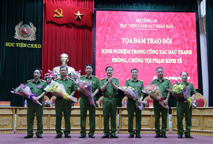 Đại tá Nguyễn Hải Hưng - Trưởng Khoa Cảnh sát kinh tế tặng hoa các đại biểu tham dự buổi tọa đàm