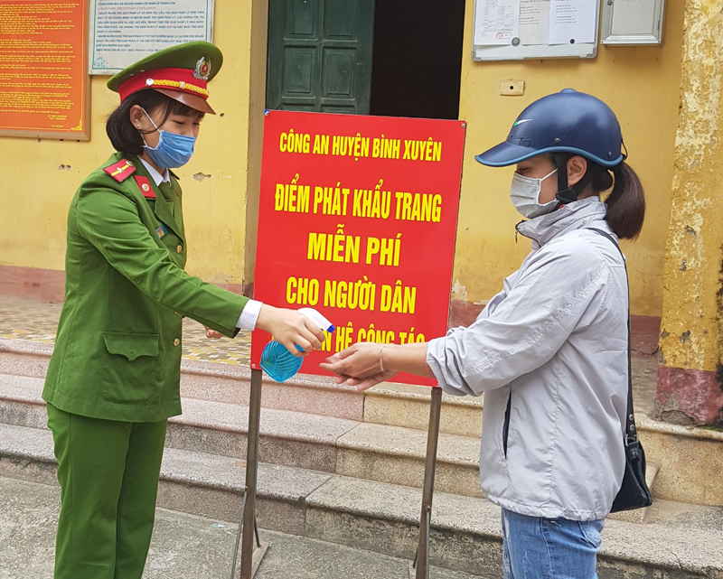 Thiếu úy Trần Khánh Mỵ khử trùng cho người dân đến làm việc