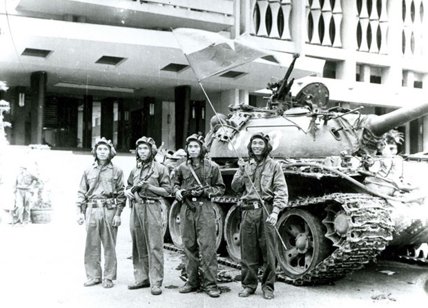 Bốn chiến sỹ Binh đoàn Hương Giang cắm cờ trên nóc Phủ Tổng thống ngụy Sài Gòn ngày 30/4/1975 (Người cầm cờ là chiến sĩ Bùi Quang Thận).