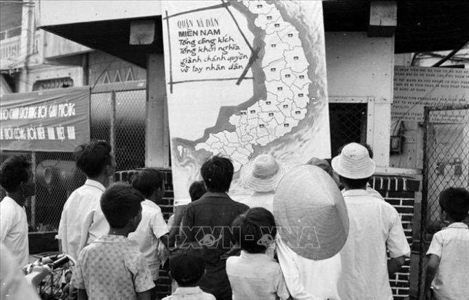 Trong ảnh: Nhân dân thị xã Phan Thiết (Bình Thuận) vừa được giải phóng theo dõi tin chiến thắng trên bản đồ chiến sự tại phòng thông tin thị xã (tháng 4/1975). Ảnh: Mai Hưởng - TTXVN