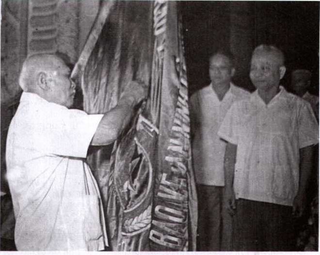 Chủ tịch nước Tôn Đức Thắng gắn Huân chương Hồ Chí Minh lên cờ truyền thống của lực lượng CAND, ngày 19-8-1975.