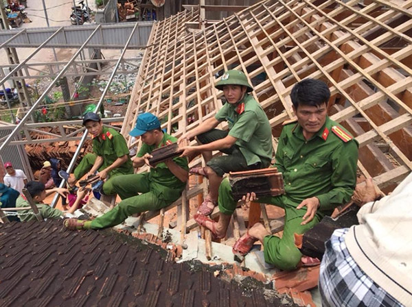 Cán bộ, chiến sỹ Công an huyện Kỳ Sơn, Nghệ An giúp dân sửa chữa nhà cửa sau lũ.