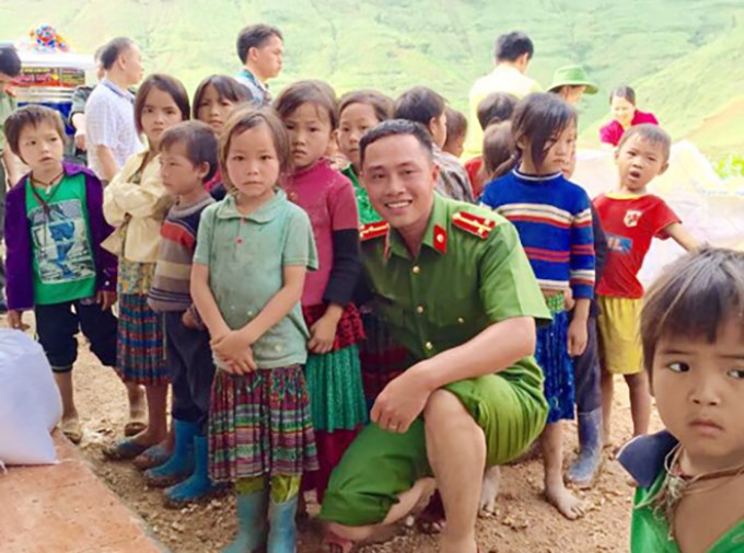 Thiếu tá Trần Anh Tuấn cùng các em học sinh trong Lễ bàn giao 2 phòng học mới cho điểm trường Lũng Lầu B - Tiểu học Khau Vai, Mèo Vạc, Hà Giang