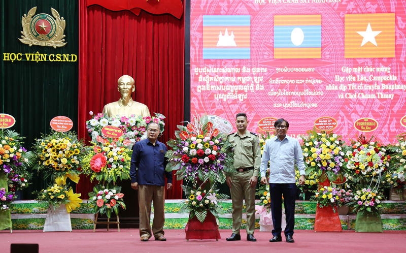Trung tá Viêng Sắc Sút Thi Sán, Phó Tùy viên Quốc phòng, Đại sứ quán nước CHDCND Lào tại Việt Nam tặng hoa chúc mừng học viên Lào nhân dịp tết cổ truyền Bunpimay