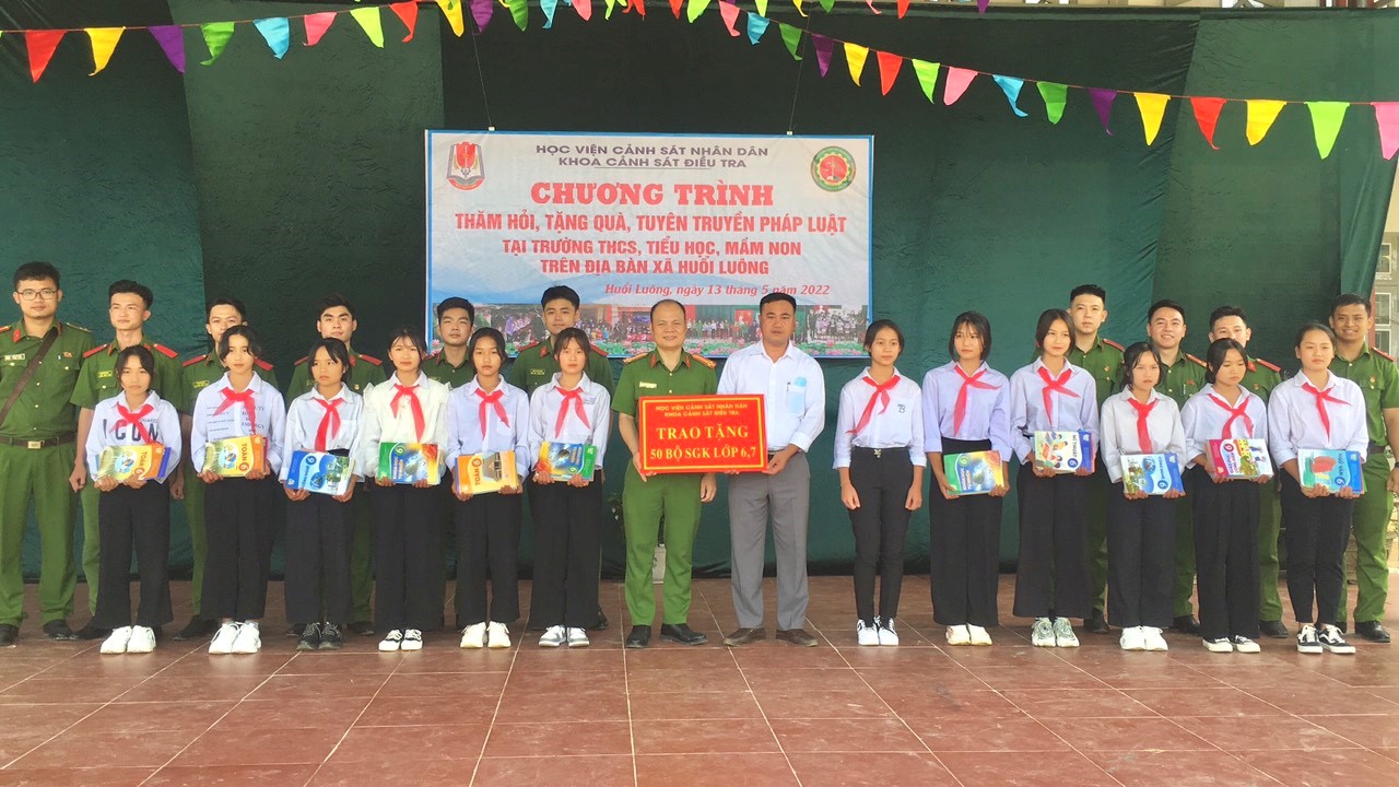 Thượng tá Nguyễn Ngọc Minh - Trưởng khoa Cảnh sát điều tra trao tặng quà cho các em học sinh tại địa bàn xã Huổi Luông