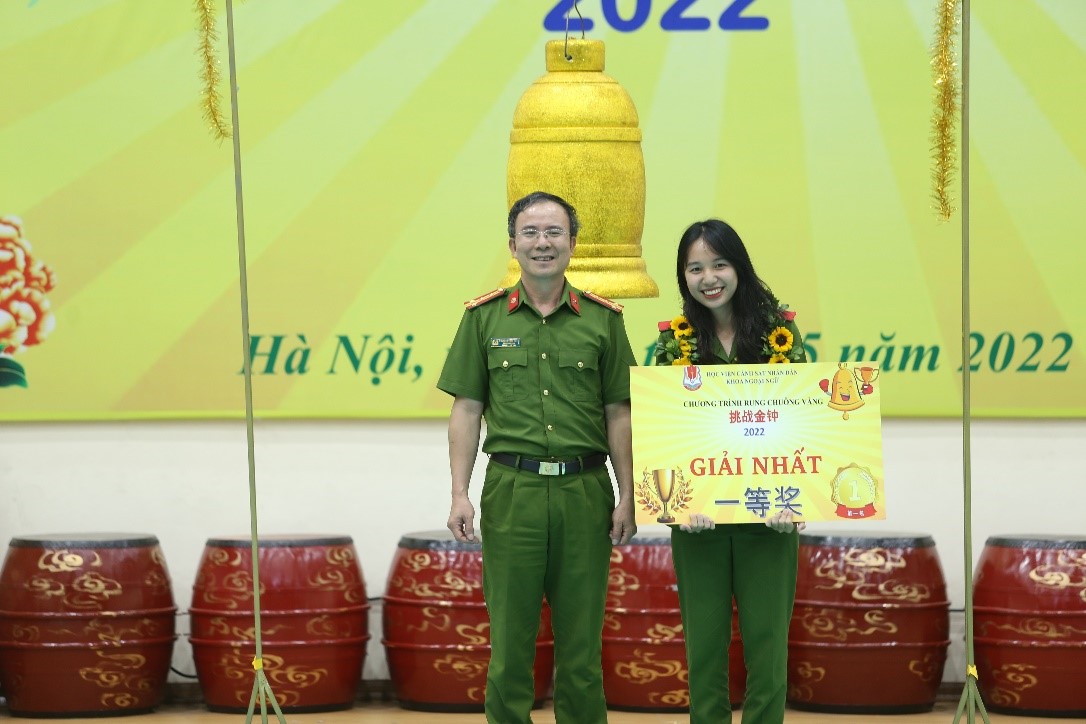 Đại tá, TS Nguyễn Quang Hùng, Trưởng Khoa Ngoại ngữ trao giải Nhất cho thí sinh Trần Thu Phương (lớp B3B-D46)