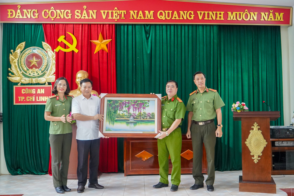 Đại tá Nguyễn Đăng Sáu và Thượng tá Nguyễn Thị Quế tặng quà của Cụm thi đua số 6 cho Bạn Chỉ huy CA thành phố Chí Linh