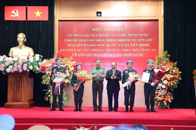 Chủ tịch nước Nguyễn Xuân Phúc và Bộ trưởng Bộ Công an Tô Lâm trao quyết định và tặng hoa cho 4 sĩ quan