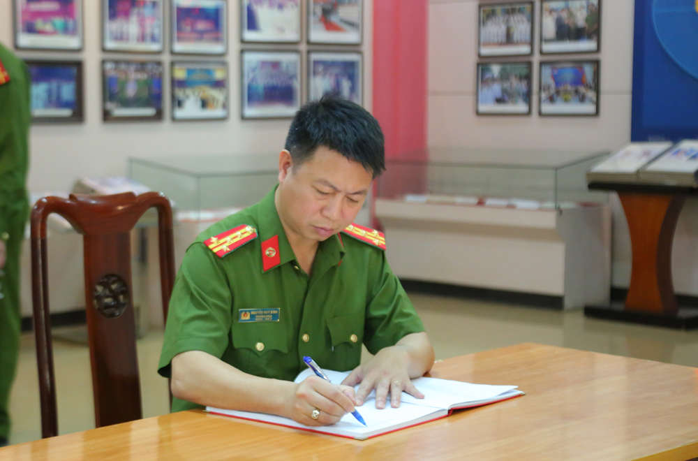 Đại tá, PGS. TS Nguyễn Huy Bình - Trưởng khoa Cảnh sát hình sự viết sổ lưu niệm tại Bảo tàng Công an nhân dân