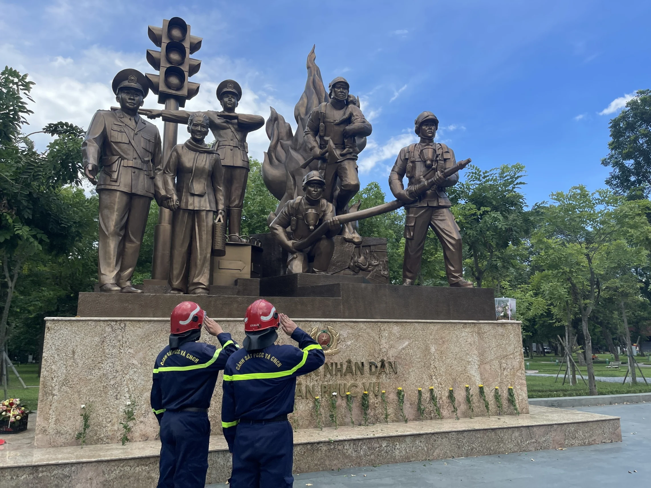 Cán bộ chiến sĩ Cảnh sát Phòng cháy, chữa cháy và cứu nạn cứu hộ đặt hoa trước tượng đài Công an nhân dân vì dân phục vụ.